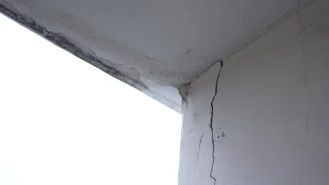 A white concrete wall corner showing a prominent vertical crack along Stock Footage 344704232