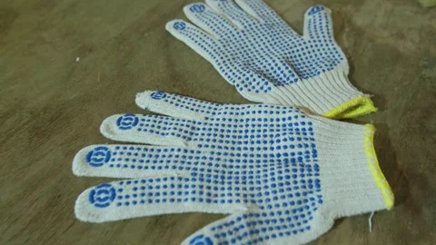 White construction gloves with blue pimples on a wooden table Stock Footage 145322829