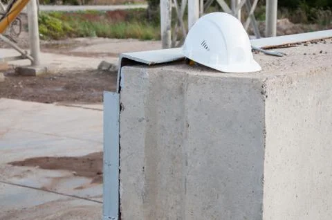 White construction hat on a concrete slab. Stock Photos