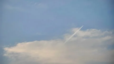White contrail from a jet plane flying high in the blue sky Stockbeeldmateriaal 312314970
