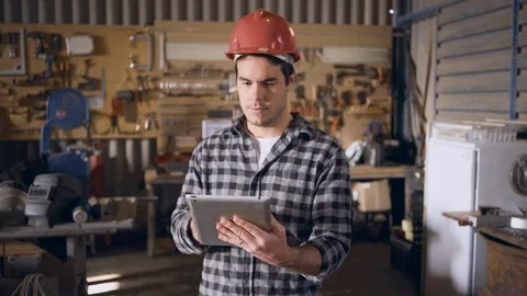 White contruction worker working on a tablet in a workshop using the wifi Video stock 94929836