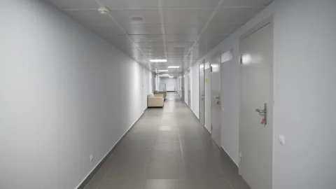 White corridor stretches with soft sofas opposite offices Stockbeeldmateriaal 316753753