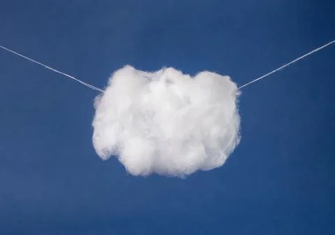 White cotton cloud hanging on strings on dark blue background. Surrealism style Stock Photos