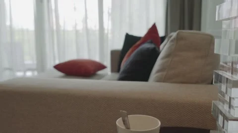 A white couch with a black and red pillow on it Stock Footage 313371363