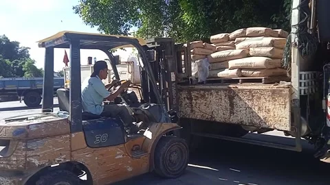 White Crane Truck Loading Cement Assisted by Forklift Stock Footage 309306859
