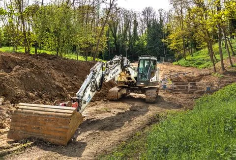 White crawler excavator working at a construction site for pipe installation. Stock Photos