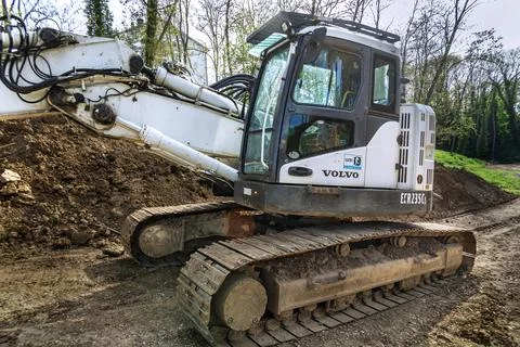 White crawler excavator working at a construction site for pipe installation. 库存照片