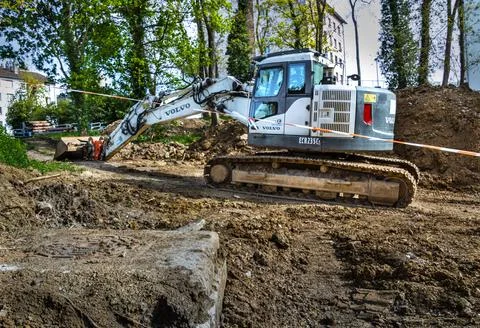 White crawler excavator working at a construction site for pipe installation. 库存照片
