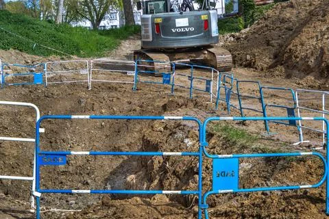 White crawler excavator working at a construction site for pipe installation. 库存照片