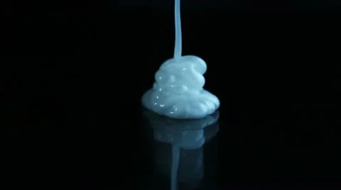 White cream is poured on a black background Stock Footage 10803441