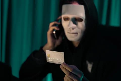 White criminal mask calling to credit card owner to threaten ransom. Pecuniary. Foto stock