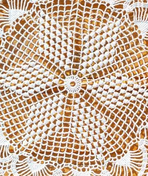 A white crochet pattern with a gold background Stock Photos