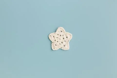 The white crocheted star pattern on a blue background. Stock Photos
