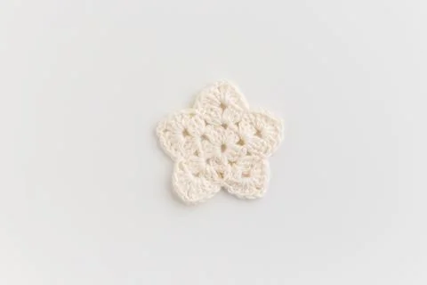 The white crocheted star pattern on a white background. Stock Photos