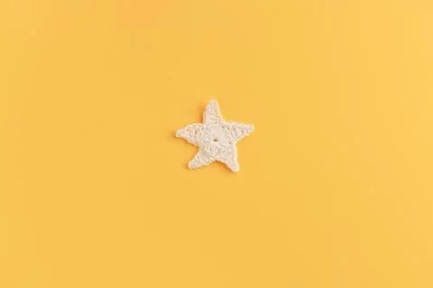 The white crocheted star pattern on a yellow background. Stock Photos