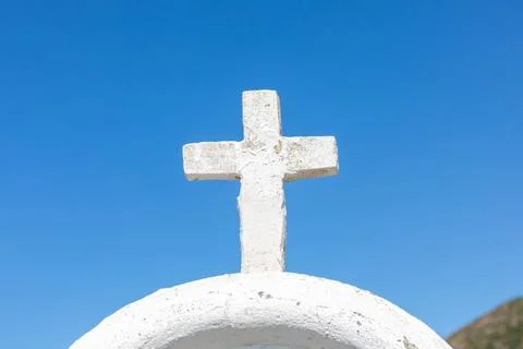 White cross standing on whitewashed dome against blue sky Stock Photos