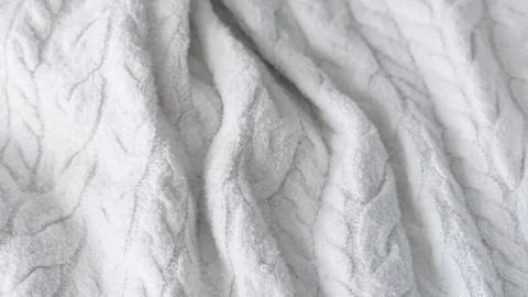 White crumpled cable knit wool sweater fabric texture with waves close up Stock Photos