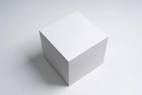 White cube box on a white surface Stock Photos