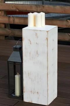 White cube , on it are white candles. A number of metal lantern. Aged and Stock Photos