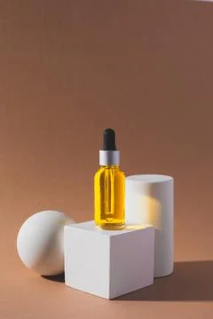 White cube podium with bottle of essential oil on it Stock Photos