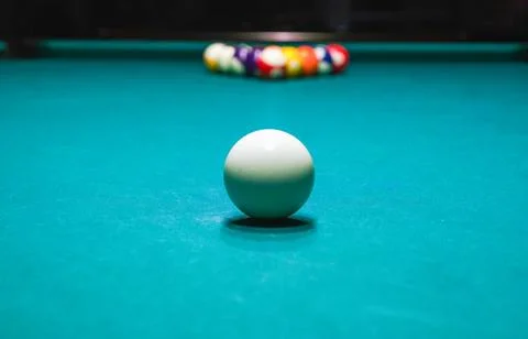 White cue ball on billiard table with rack in background Stock Photos