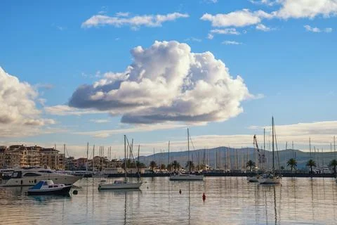 White Cumulus cloud in blue sky. View of port in Tivat city, Montenegro Stock Photos