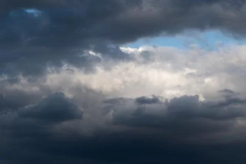 White cumulus cloud framed with dark ominous clouds Stock Photos