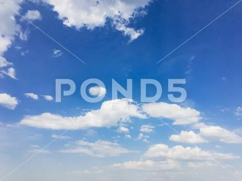 White cumulus clouds against blue sky Stock Photos