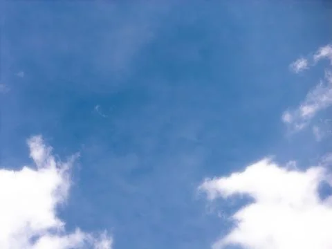 White Cumulus Clouds Bordering a Broad Blue Sky Opening Stock Photos