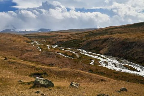 White Cumulus clouds come down from the mountains, autumn landscape in the st Stock Photos