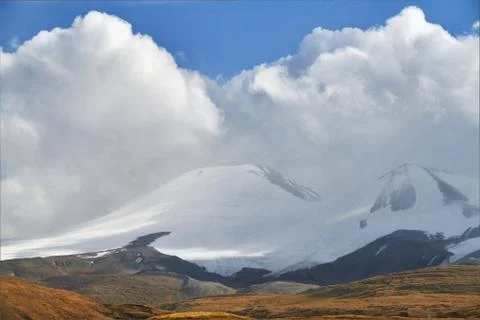 White Cumulus clouds come down from the mountains, autumn landscape in the st Stock Photos