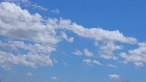 White cumulus clouds drifting across a clear blue sky. Stock Footage 340129843