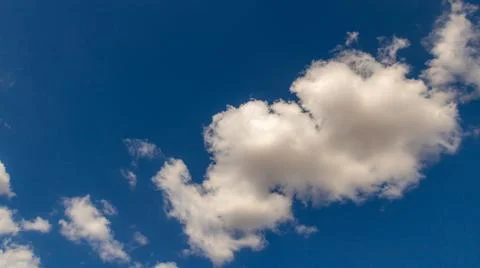 White cumulus clouds drifting across deep blue sky with large copy space in.. Stock Photos