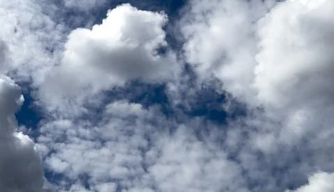 White cumulus clouds fill a deep blue sky. Puffy cloudscape creates a bright Foto stock