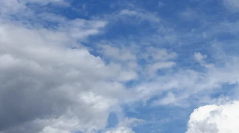 White cumulus clouds float across the blue sky Stock Footage 49941589