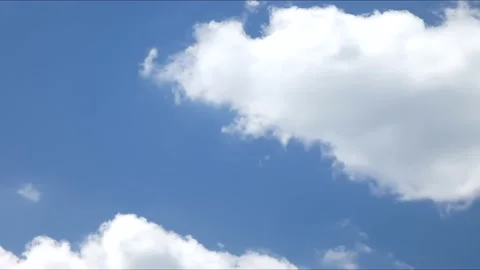 White cumulus clouds float against a blue sky Video stock 157835032