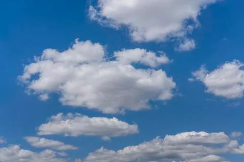 White cumulus clouds float beautifully in the blue sky. Stock Photos