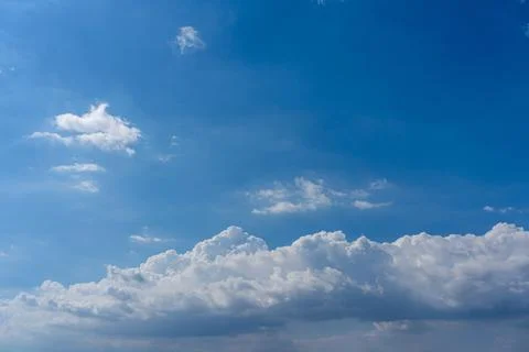 White cumulus clouds floating in the blue sky Stock Photos