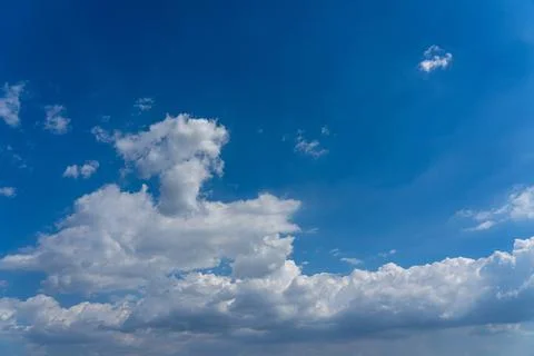 White cumulus clouds floating in the blue sky Stock Photos