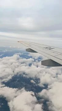 White cumulus clouds with gaps under the wing of an airplane. Photos