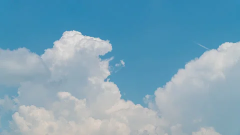 White cumulus clouds move fast in the blue sky Stock Footage 133145175