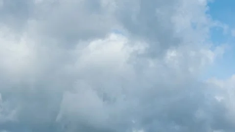 White cumulus clouds moving fast across a bright blue sky. Time lapse.  Stock Footage 285317945