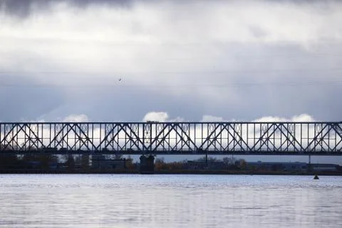 White cumulus clouds pass bridge over the Northern Dvina River. Stock Photos