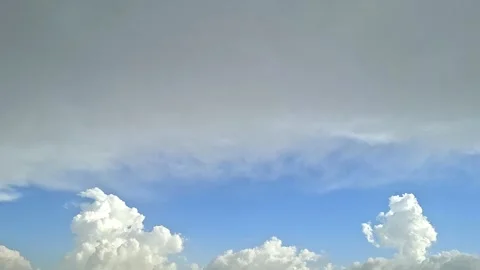 White Cumulus Clouds Rising Below Grey and Blue Layered Sky Video stock 332995832