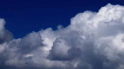 White cumulus clouds speeding furiously across an indigo sky. Stock Footage 52327193