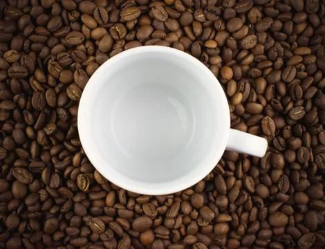 White Cup and scattered roasted coffee beans Stock Photos