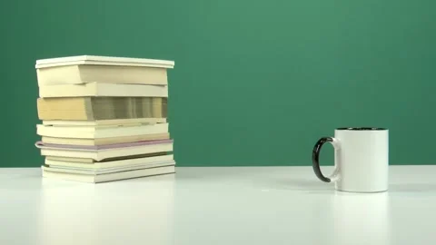 White Cup and Stack of Books on White Table with Green Screen Background Stock Footage 344675742
