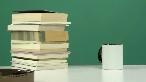 White Cup and Stack of Books on White Table with Green Screen Background Stock Footage 344677940
