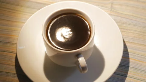 The white cup of black coffee is shaking from the earthquake. The coffee in the Vidéo 142321997