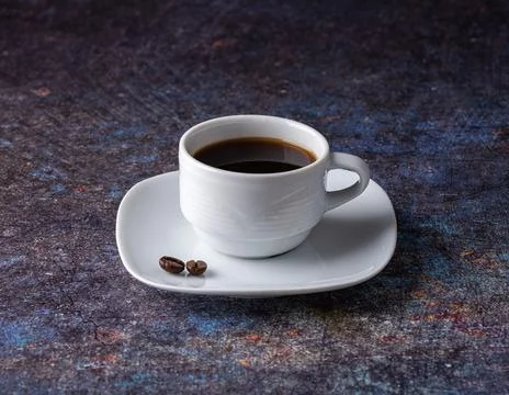 White cup with black coffee on a white saucer. Stock Photos